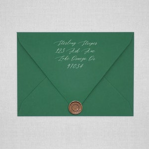 May include: A green envelope with a wax seal. The address is written in white ink: Sterling Striper, 123 Ash Ave, Lake Oswego, OR 97034.