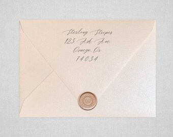 May include: A light pink envelope with a wax seal. The envelope has a handwritten address that reads "Sterling Stripes, 123 Ash Ave, Oswego, Or, 74034".