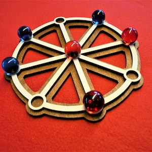 May include: A wooden wheel with eight spokes and a central hub, decorated with six marbles. Two red marbles are placed on the outer rim, two blue marbles are placed on the outer rim, and two red marbles are placed in the centre of the wheel.