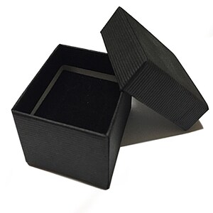 May include: A black square-shaped gift box with a black lid. The box is lined with black velvet.