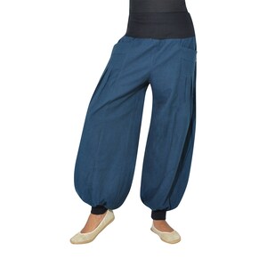 Puede incluir: Un pantal&oacute;n de pierna ancha de color azul oscuro con cintura el&aacute;stica negra y tobillos con pu&ntilde;os.