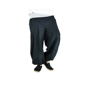 May include: Black harem pants with a relaxed fit. The pants have a high waist, pleats, and pockets. The ankles are gathered. The person is wearing black shoes. The pants are made of a soft, flowing fabric.