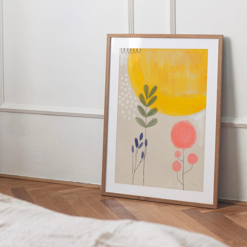 Może przedstawiać: Wydruk abstrakcyjnej sztuki w ramie z ż&oacute;łtym słońcem, r&oacute;żowymi kwiatami i zielonymi liśćmi na beżowym tle.