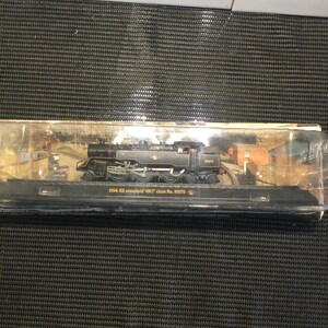 May include: A black model train with gold accents, labeled "1954 BR standard '4MT' class No. 80079".