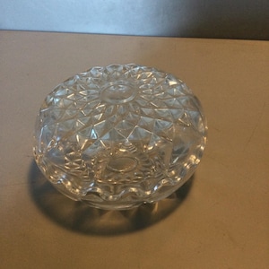 Pode incluir: Uma tigela de vidro transparente com um padrão de diamante na parte superior e uma borda festonada.