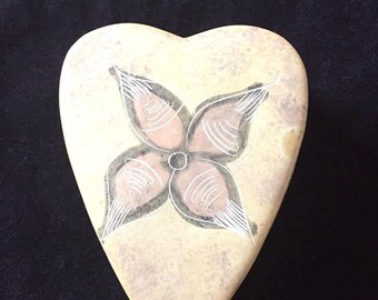 May include: A heart-shaped stone box with a hand-painted flower design in shades of pink, white, and gray.