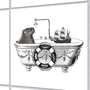 May include: A monochrome illustration depicts a capybara in a decorative bathtub, complete with a miniature ship and a lifebuoy. The bathtub has ornate detailing and a shower head. A whimsical image of a capybara enjoying a bath.
