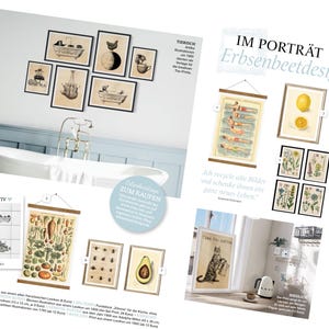 May include: A collection of vintage botanical prints in black frames, featuring illustrations of lemons, flowers, and a cat. The prints are displayed on a white wall with a white bathtub in the background. The text "IM PORTR&Auml;T Erbsenbeetdesign" is visible in the upper right corner of the image.
