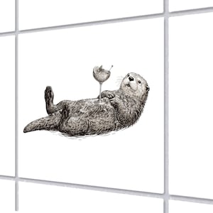 Può includere: Illustrazione in bianco e nero di una lontra rilassata che tiene in mano un cocktail. La lontra è sdraiata sulla schiena, con un bicchiere da cocktail appoggiato sul petto. Il cocktail ha una fetta di limone e un bastoncino. Lo sfondo è bianco.