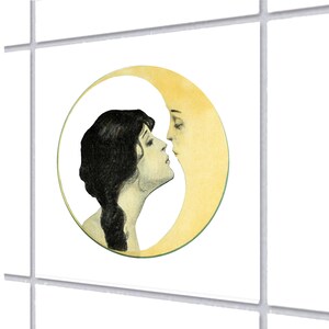 Può includere: Illustrazione circolare in stile vintage raffigurante una donna che guarda una luna crescente con un volto. La donna ha i capelli scuri ed è di profilo, la luna è di colore giallo pallido. L'opera d'arte ha un'estetica retrò.