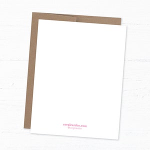 Back of card show which is plain white with corgicardco website and instagram written on it. With a brown kraft envelope behind it. Flat lay of the card on a light white wood floor pattern.
