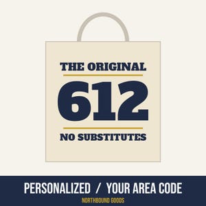 May include: A cream-colored shopping bag with a handle featuring the dark blue text THE ORIGINAL 612 NO SUBSTITUTES. Below the bag, the text reads PERSONALIZED / YOUR AREA CODE and NORTHBOUND GOODS in white and yellow lettering.