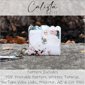 May include: A white wallet with a floral pattern, a scalloped edge, and a snap closure. The wallet has a wrist strap and the text "Calista Wallet". The image also includes the text "Pattern Includes PDF Printable Pattern, Written Tutorial, YouTube Video Links, Projector, AO, & Cut Files."
