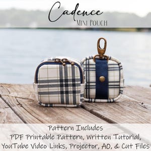 Può includere: Due mini pochette con motivo a quadri in crema, nero e blu navy. Una pochette ha una cerniera e una piccola tasca, l'altra ha un cinturino blu navy e una chiusura color oro. Il testo "Cadence MINI POUCH" è in alto.