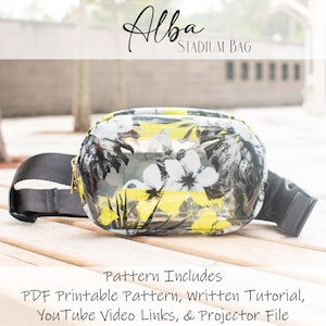 Puede incluir: Bolso de estadio transparente con estampado floral en blanco y negro sobre fondo amarillo. El bolso tiene una correa negra ajustable y cierre de cremallera. El texto "Alba Stadium Bag" es visible en la parte superior de la imagen. El texto "Pattern Includes PDF Printable Pattern, Written Tutorial, YouTube Video Links, & Projector File" es visible en la parte inferior de la imagen.
