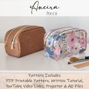 May include: Two zippered pouches, one brown faux leather and one clear with a floral print. The pouches are on a white surface with makeup brushes and a comb.