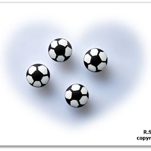 Puede incluir: Cuatro balones de fútbol blanco y negro sobre un fondo blanco.