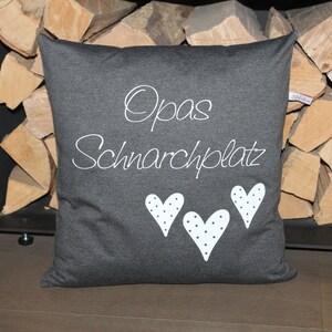 May include: A gray pillow with white text that says "Opa's Schnarchplatz" and three white hearts with black polka dots.