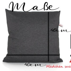 May include: A dark gray pillow with a zipper closure. The pillow is 40 inches by 40 inches. The text "Mabe" is written at the top of the image. The text "M&auml;dchen sucht Kleid" is written at the bottom of the image.