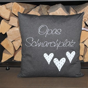 May include: A gray pillow with white text that says "Opa's Schnarchplatz" and three white hearts with black polka dots.