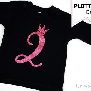 May include: Black long-sleeved shirt with a pink glittery number 2 and a crown design. The shirt has the text "PLOTTER Datei" in a white banner. The shirt is likely for a child's birthday.