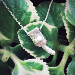 May include: A silver necklace with a mushroom pendant. The mushroom is detailed with a textured cap and stem.