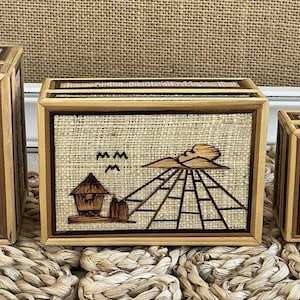 May include: Set of three wooden boxes with a woven texture and a framed design. Each box features a detailed illustration of a landscape with the word "PHILIPPINES" on the largest box.