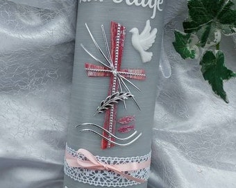 May include: Gray baptism candle with a white dove, a pink cross, and wheat stalks. The candle is decorated with a pink ribbon and lace. The text "Zur Taufe" and "Theresa 16.04.2023" is written on the candle.