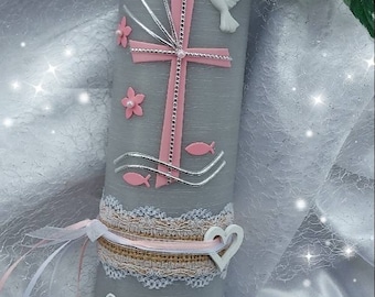 May include: A gray candle with a pink cross, white dove, and pink flowers. The candle has a white lace trim and a white heart. The candle is decorated with the name "Liliana" and the date "21.05.2023".