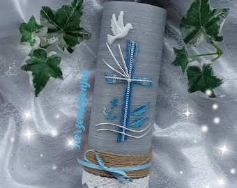 Pode incluir: Uma vela de batizado cinza com uma pomba branca, uma cruz azul e uma âncora azul. A vela é decorada com uma fita azul e uma renda branca. O nome "David" e a data "15.05.2021" estão escritos na vela.