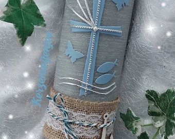 May include: A gray baptism candle with a blue cross, white doves, butterflies, and fish. The candle is decorated with a burlap ribbon and a white anchor. The text "Leo 04.07.2021" is written on the candle.