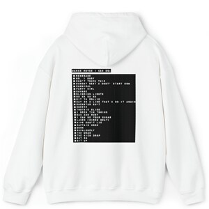 Puede incluir: Sudadera con capucha blanca con una lista de movimientos de baile impresa en la parte posterior en un rect&aacute;ngulo negro. El texto incluye frases como "Renegade", "Tootsie Slide" y "Say So". La sudadera tiene capucha y bolsillo de canguro.