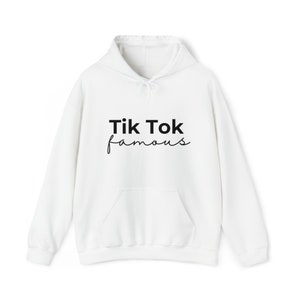 Puede incluir: Sudadera blanca con bolsillo delantero y capucha con cord&oacute;n. El texto "Tik Tok famous" est&aacute; impreso en negro en la parte delantera. La sudadera est&aacute; hecha de un material suave.
