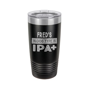 May include: Black stainless steel tumbler with a silver lid. The tumbler has the text "FRED'S BLOOD TYPE IS IPA+" engraved on the side.