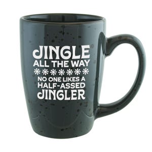 May include: A black ceramic coffee mug with white text that reads "JINGLE ALL THE WAY" with snowflakes and "NO ONE LIKES A HALF-ASSED JINGLER". The mug has a speckled finish and a large handle.