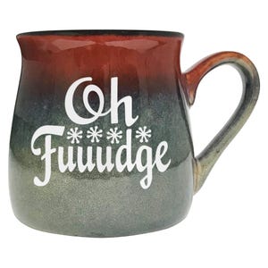 May include: A ceramic mug with a rounded shape and a large handle. The mug has a gradient color scheme, transitioning from a dark red at the top to a green-gray at the bottom. White text on the front reads "Oh Fuuuudge" with asterisks. The mug is designed for beverages.