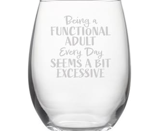 May include: Clear glass wine glass with the text "Being a functional adult every day seems a bit excessive" etched on the side.