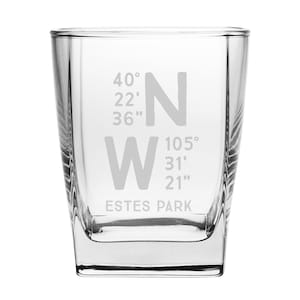 May include: A clear glass tumbler with the coordinates 40° 22' 36" N 105° 31' 21" W and the text "ESTES PARK" etched on the front.