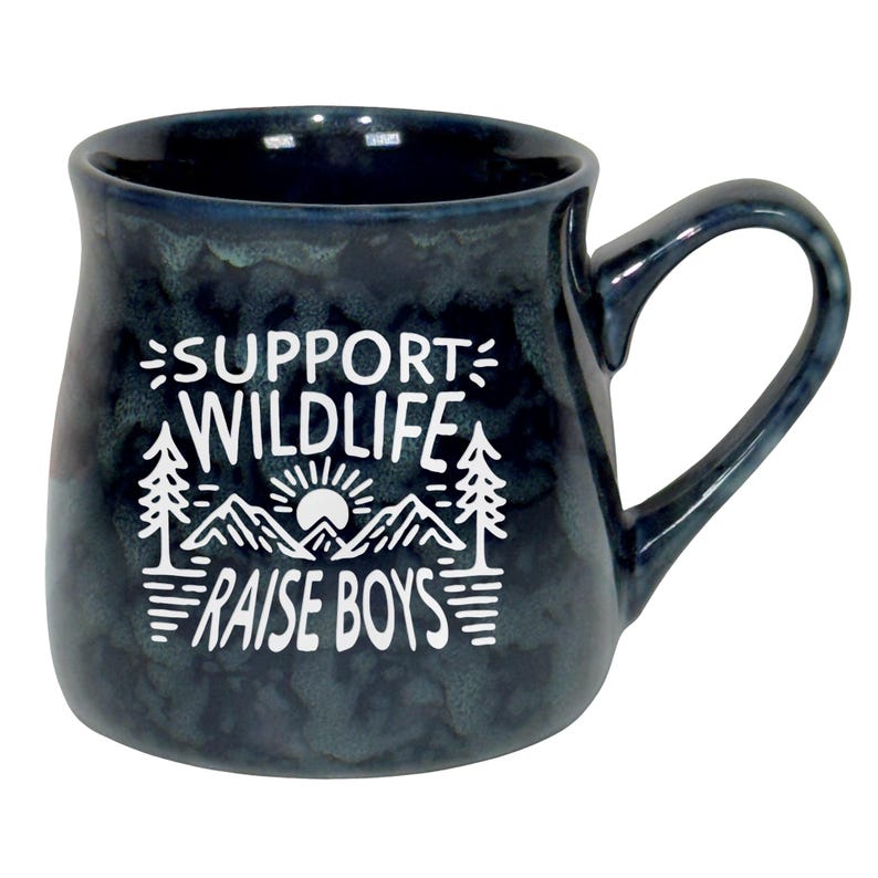 May include: A dark blue ceramic mug with a white graphic that reads "SUPPORT WILDLIFE RAISE BOYS". The design includes mountains, trees, and a sun. The mug has a curved handle and a speckled finish.
