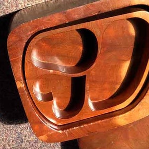 May include: A wooden serving tray with a unique, organic shape and multiple compartments. The tray is made of a rich, reddish-brown wood with a natural grain pattern.