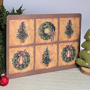 Könnte beinhalten: Ein rechteckiges, weihnachtliches Dekobrett mit sechs illustrierten Quadraten. Jedes Quadrat zeigt einen Weihnachtsbaum oder einen Kranz mit roten Schleifen. Das Brett hat einen braunen Rand und einen Vintage-Papier-Hintergrund.