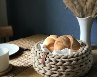 Bread basket for table decoration, woven box for fruit, nuts and small things, aesthetic storage in a warm interior design.