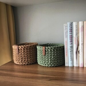 Una cesta decorativa tejida, un recipiente para guardar objetos pequeños, un elemento decorativo en un estante de una habitación o baño. imagen 6