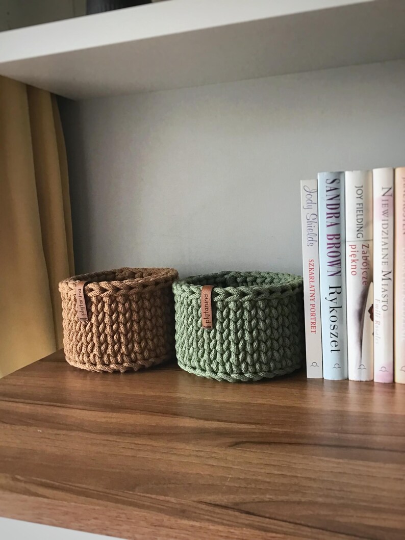 Una cesta decorativa tejida, un recipiente para guardar objetos pequeños, un elemento decorativo en un estante de una habitación o baño. imagen 6