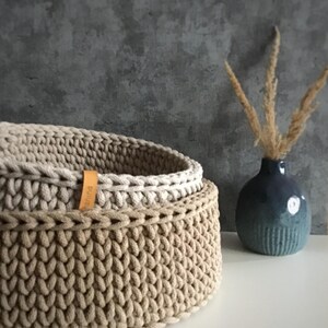 Una cesta decorativa tejida, un recipiente para guardar objetos pequeños, un elemento decorativo en un estante de una habitación o baño. imagen 11