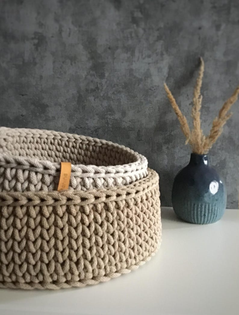 Una cesta decorativa tejida, un recipiente para guardar objetos pequeños, un elemento decorativo en un estante de una habitación o baño. imagen 11