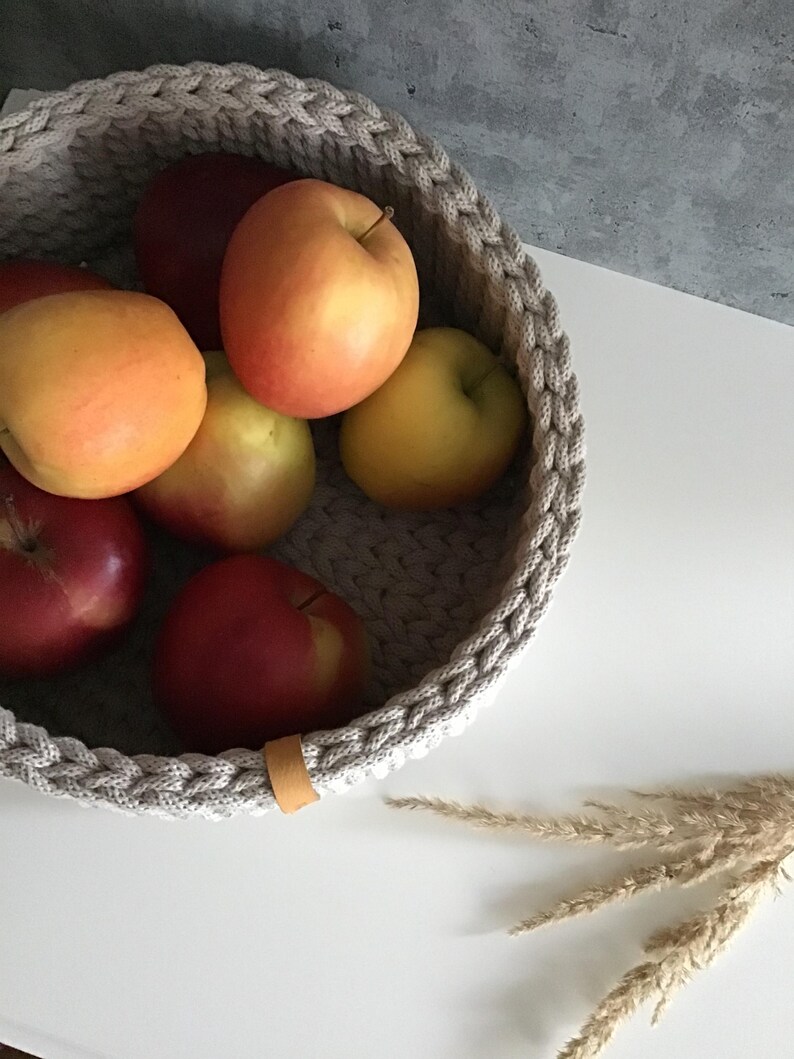 Una cesta decorativa tejida, un recipiente para guardar objetos pequeños, un elemento decorativo en un estante de una habitación o baño. imagen 5