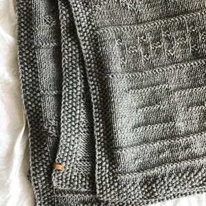 Decke aus Merinowolle und Baumwolle, ein dünnes aber warmes Strickplaid mit Patchworkoptik, ein Wohnaccessoire für jede Jahreszeit