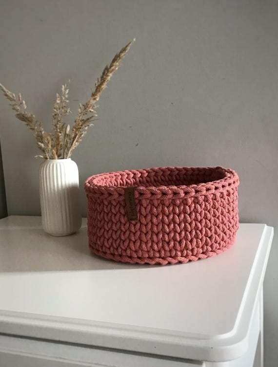 A decorative woven basket, a container for storing small items, a decorative accent on a shelf in a room or bathroom.