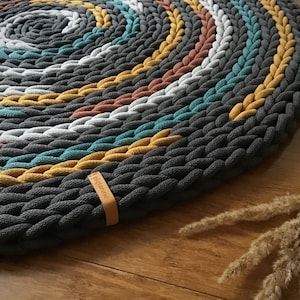 A designer round rug, a thick and fluffy rug in vintage colors, an unusual interior decoration, an aesthetic living room decor.